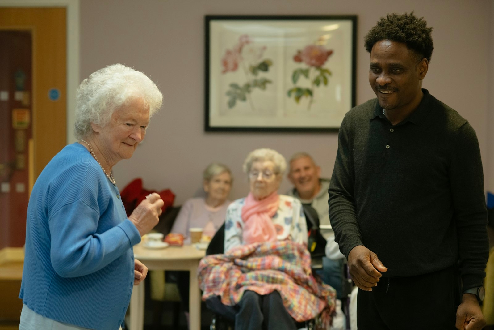 Pflegeheim-Gemeinschaftsraum — ältere Menschen mit Pflegerin